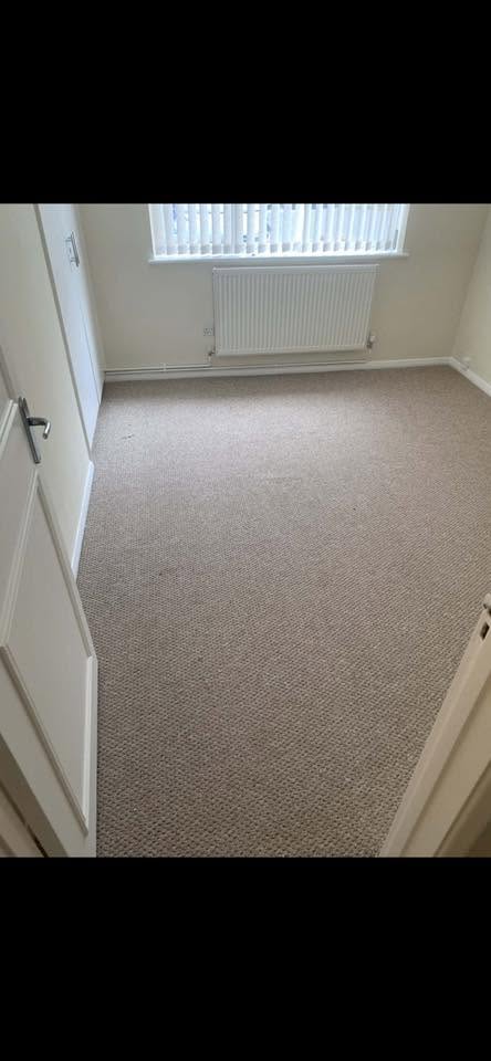 Beige carpet fitted in an empty bedroom with a window