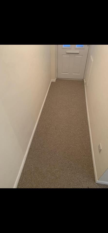 Beige carpet fitted along a hallway to the front door