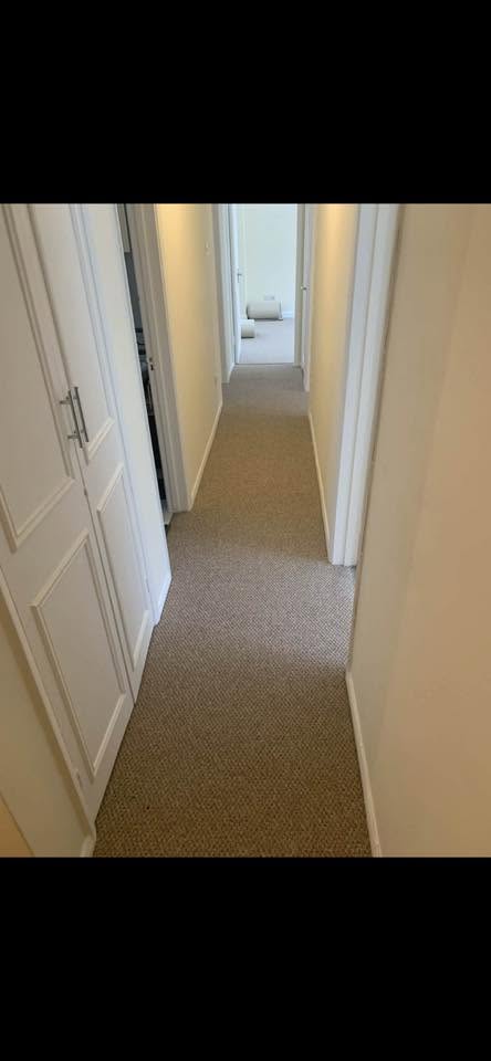 Beige carpet fitted along a long hallway